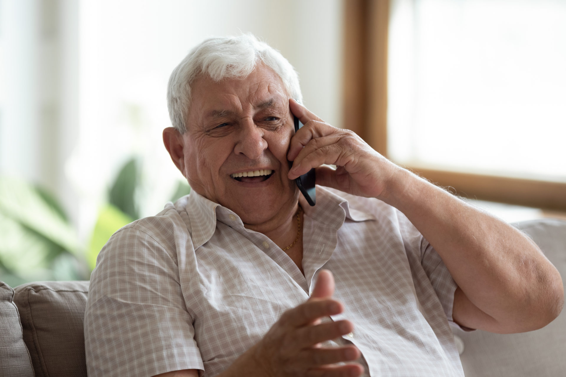 Old man laughing from a phone conversation