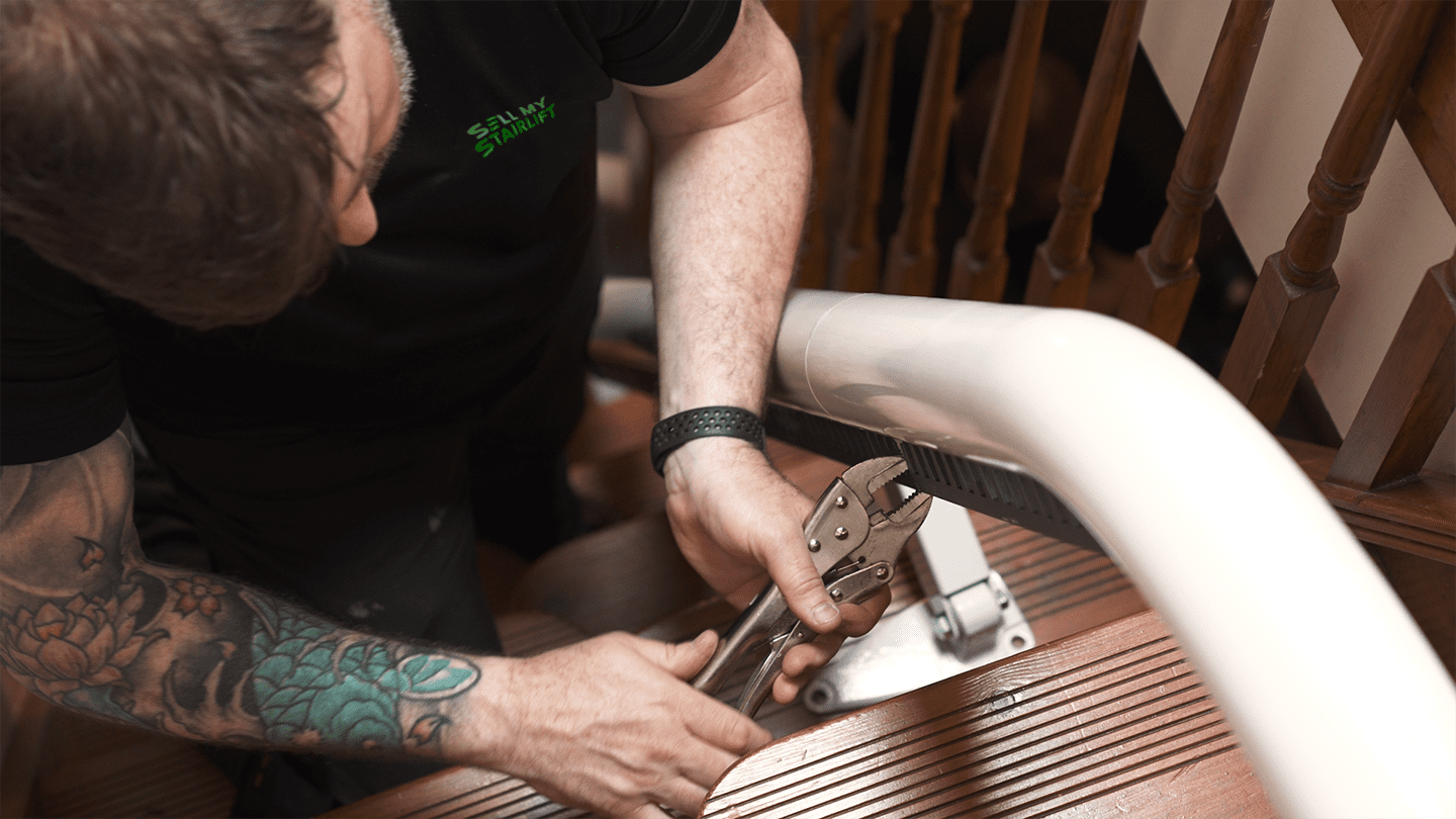 Expert stairlift engineer removing a stairlift rail.